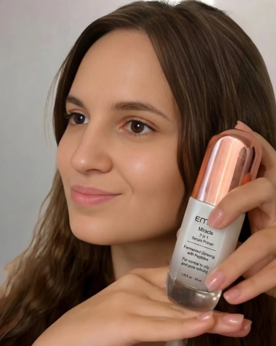Woman holding a skincare product with a neutral background | Veronika Hirich